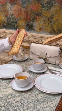 Deux tasses de chocolat chaud sont posées sur une table en marbre, accompagnées de tranches de pain croustillant.