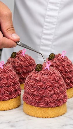 Mont-blanc à la crème rose avec biscuits croquants, décorés d'un ruban rose, préparés à la pâtisserie Angelina Paris – Alma.