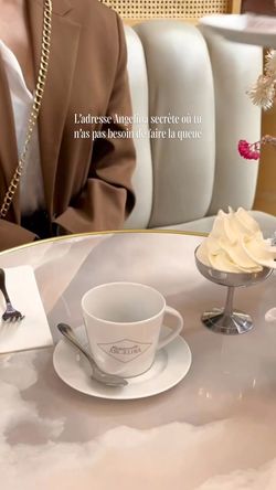 Tasse blanche et petit pot de crème fouettée sur table brillante, ambiance élégante d'un tea room avec assise capitonnée en c