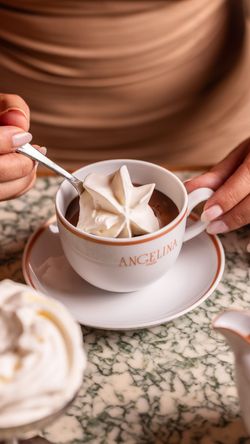 Tasse de chocolat chaud avec mousse servie dans le salon de thé Angelina Paris – Alma.