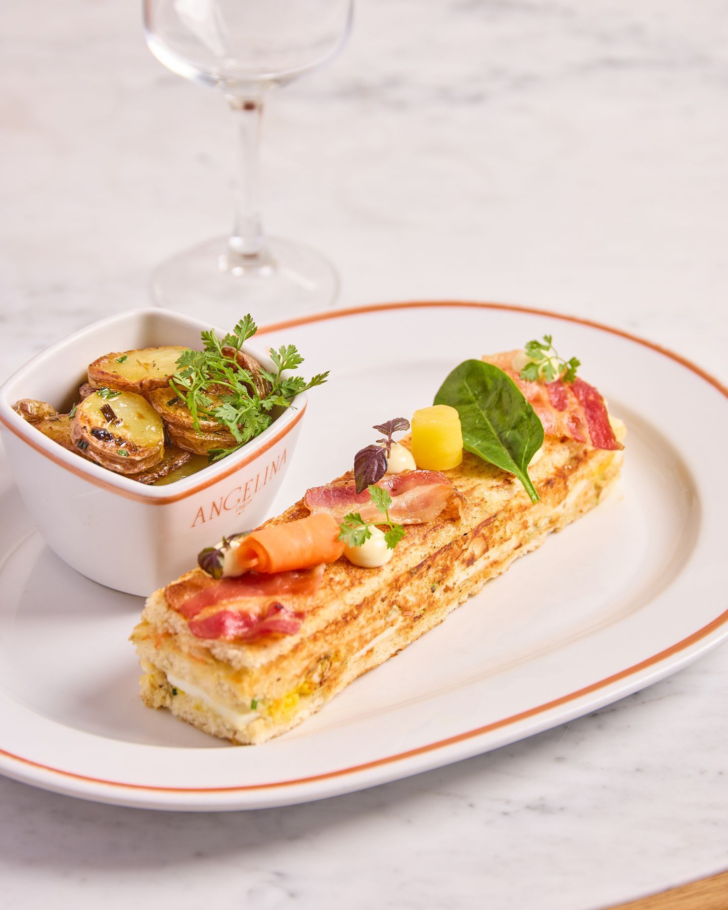 Plat avec garniture de pommes de terre et pâtisserie salée décorée de légumes et herbes sur assiette.