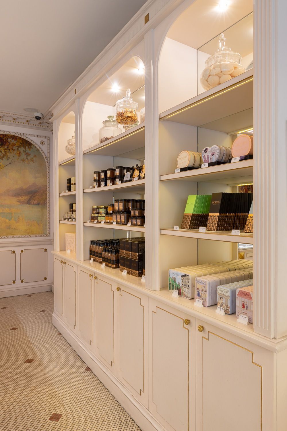 Interior view of Boutique Angelina Paris pastry shop showcasing display shelves with gourmet chocolates and sweets.